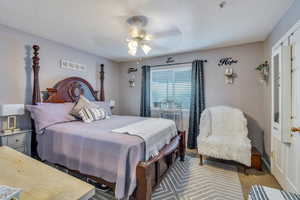Carpeted bedroom featuring a textured ceiling and ceiling fan