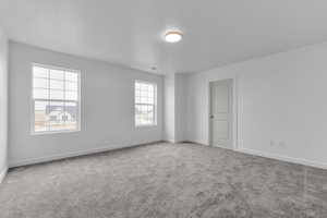 Carpeted spare room with baseboards