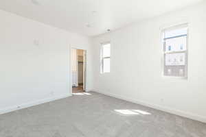 Unfurnished bedroom featuring baseboards, multiple windows, visible vents, and carpet