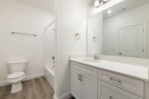 Bathroom featuring wood finished floors, visible vents, toilet, vanity, and baseboards