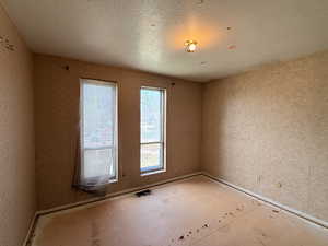 Spare room featuring a textured ceiling and visible vents