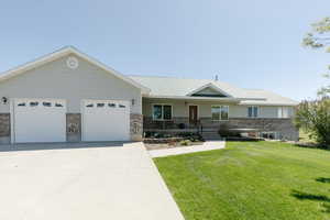 Ranch-style home featuring a front lawn, a porch, concrete driveway, an attached garage, and brick siding
