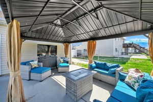 View of patio featuring fence, outdoor lounge area, and a gazebo