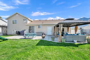 Back of house featuring fence, a yard, a patio, an outdoor living space, and a gazebo