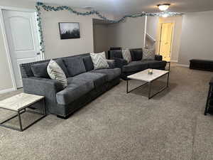 Living area with visible vents, baseboards, carpet flooring, and stairs