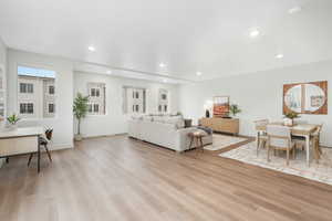 Living area with recessed lighting, light wood-style floors, and baseboards