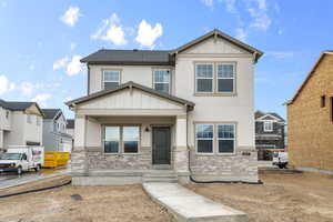 Craftsman house with board and batten siding, covered porch, brick siding, and stucco siding