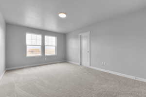 Carpeted empty room featuring baseboards
