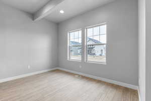 Spare room with beamed ceiling, wood finished floors, visible vents, and baseboards