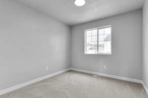 Empty room with baseboards, carpet floors, and visible vents