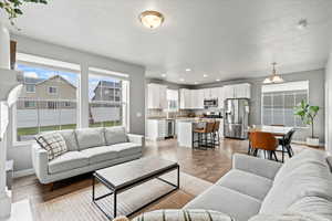 Living room featuring light wood-type flooring, a textured ceiling, and baseboards