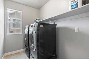 Laundry area featuring baseboards, washer and dryer, and laundry area