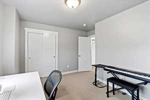 Office featuring light carpet, a textured ceiling, and baseboards