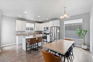 Dining space featuring baseboards, light wood finished floors, and recessed lighting
