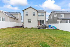 Back of property with a lawn, a patio area, a fenced backyard, and stucco siding