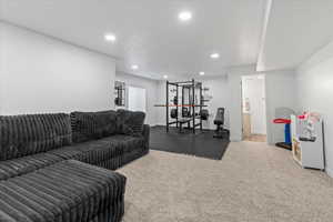 Carpeted living area with baseboards and recessed lighting