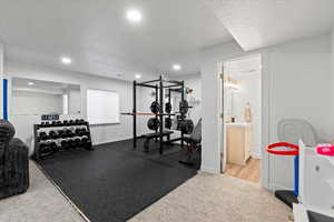 Workout room featuring carpet, baseboards, a textured ceiling, and recessed lighting
