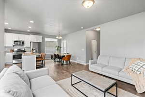 Living room with visible vents, baseboards, wood finished floors, and recessed lighting