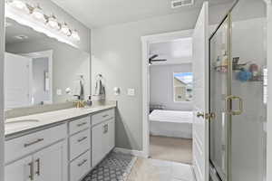 Ensuite bathroom featuring visible vents, a stall shower, ensuite bathroom, and a sink