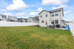 Back of house featuring a lawn, a fenced backyard, a residential view, and a patio