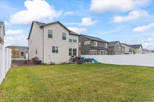 Back of house with a yard, a fenced backyard, and a residential view