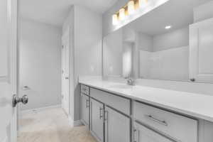 Bathroom with marble finish floor, baseboards, and vanity