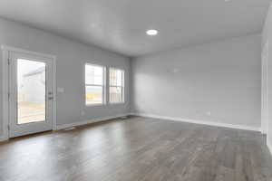 Spare room featuring hardwood / wood-style flooring and baseboards