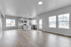 Kitchen with baseboards, appliances with stainless steel finishes, visible vents, and a kitchen island