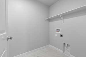 Washroom with hookup for a washing machine, electric dryer hookup, marble finish floor, baseboards, and laundry area