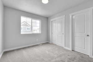 Unfurnished bedroom featuring visible vents, baseboards, carpet flooring, and a closet