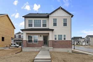 View of front of property featuring stucco siding, brick siding, and board and batten siding