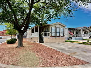Manufactured / mobile home featuring a sunroom, driveway, and covered porch