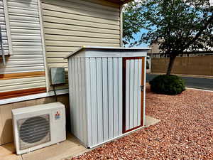 View of shed with ac unit and fence