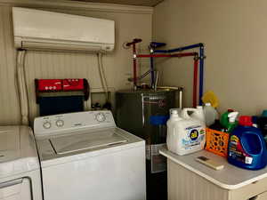 Clothes washing area with water heater, a wall mounted AC, washing machine and dryer, and laundry area