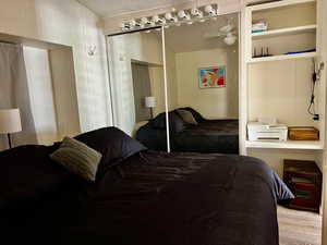 Bedroom featuring wood finished floors, a textured ceiling, and a closet