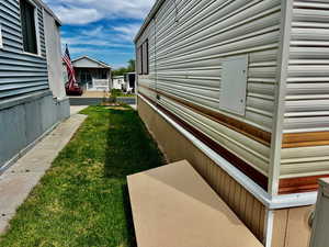 View of side of home with a yard