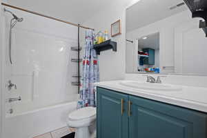 Bathroom featuring shower / bath combo, tile patterned floors, vanity, toilet, and visible vents