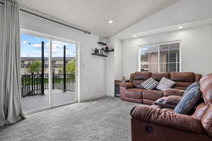 Carpeted living area featuring recessed lighting, lofted ceiling, and baseboards