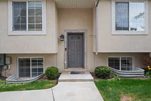 Doorway to property featuring stucco siding