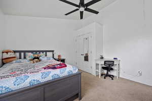 Carpeted bedroom featuring a ceiling fan and baseboards