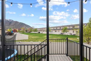Wooden deck with a trampoline, a lawn, a fenced backyard, a mountain view, and a residential view