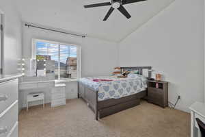 Bedroom featuring light colored carpet, ceiling fan, lofted ceiling, and baseboards