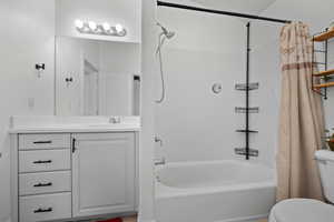 Bathroom featuring toilet, vanity, and shower / tub combo with curtain