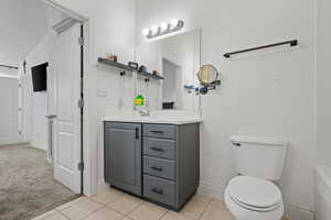 Bathroom with baseboards, tile patterned floors, vanity, and toilet