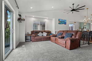 Carpeted living area featuring vaulted ceiling, recessed lighting, and a healthy amount of sunlight