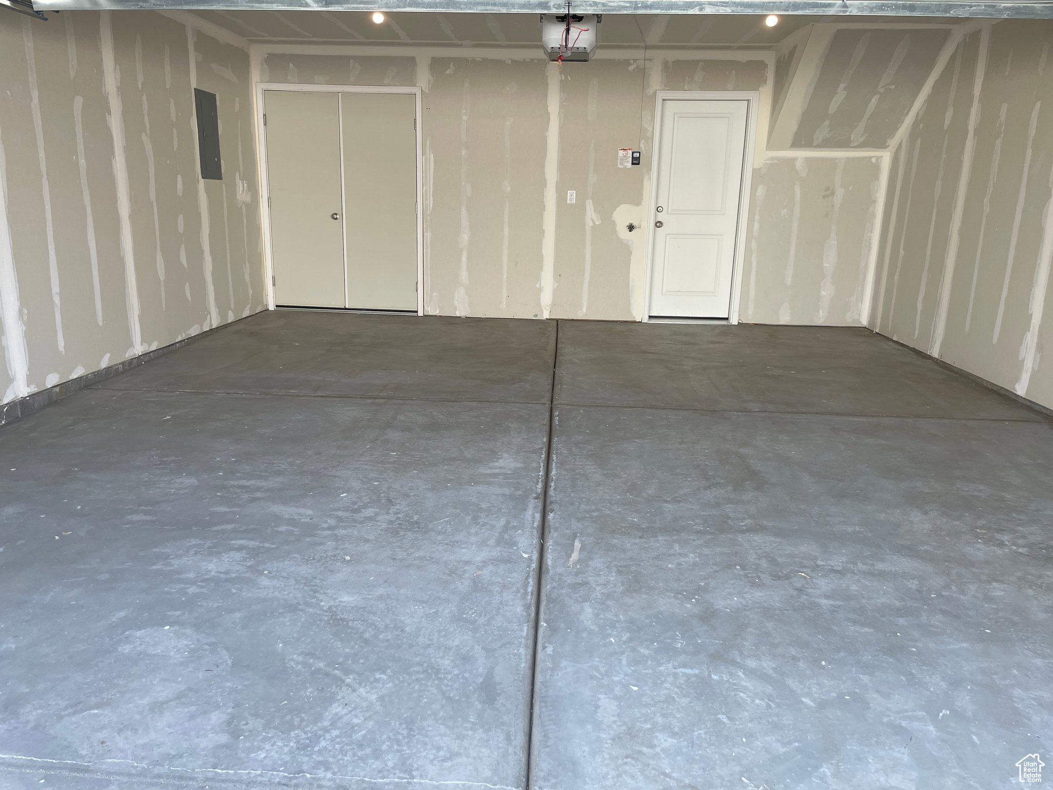 Garage with electric panel and a garage door opener