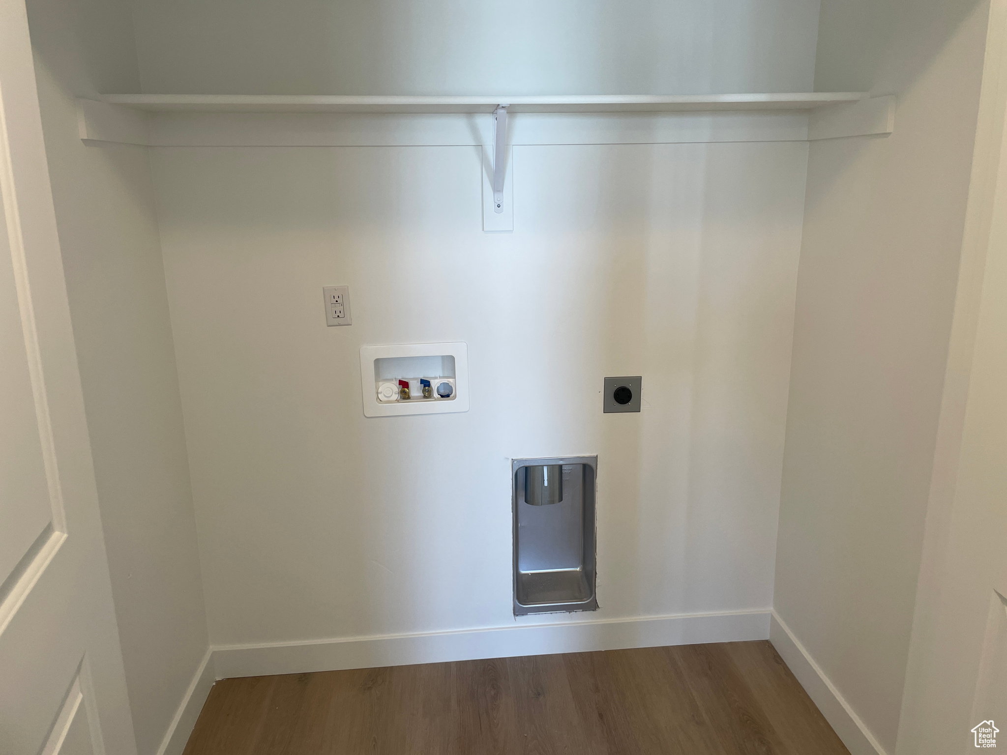 Washroom with hookup for a washing machine, wood finished floors, electric dryer hookup, baseboards, and laundry area