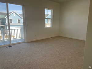 Carpeted empty room featuring baseboards and visible vents