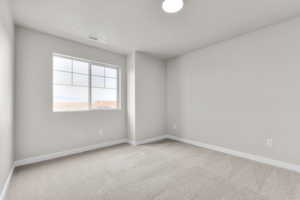 Carpeted empty room with baseboards and visible vents