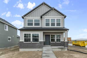 Craftsman inspired home featuring board and batten siding and covered porch